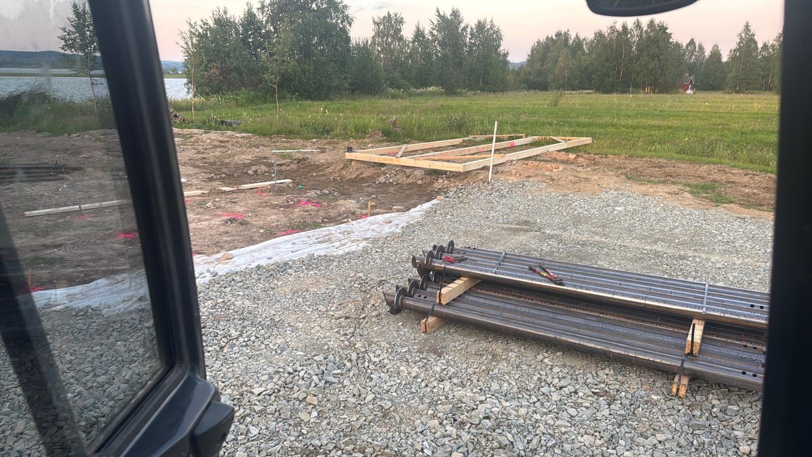 Skruvpålar redo för husgrundsinstallation på sjötomt