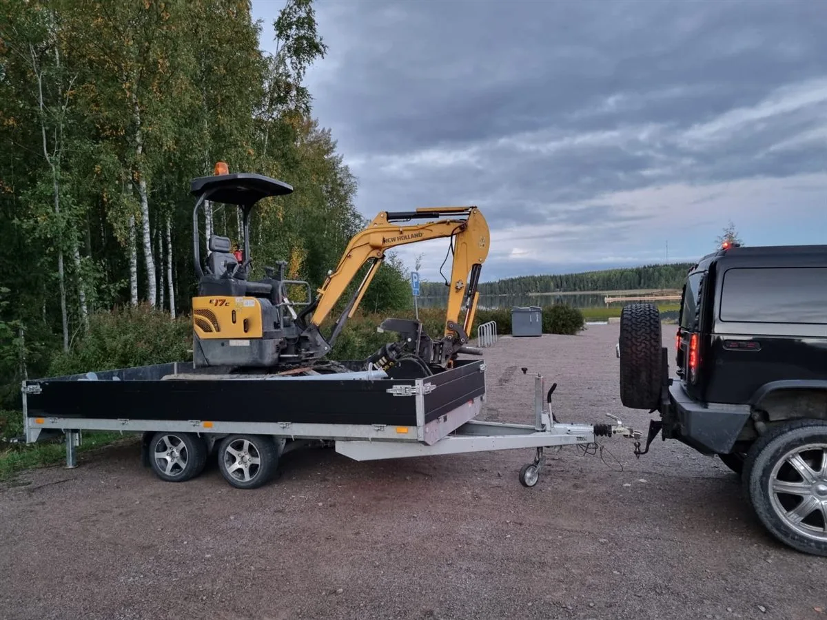 Minigrävare med skruvpålsutrustning på trailer för uthyrning